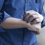 a man scratching his arm